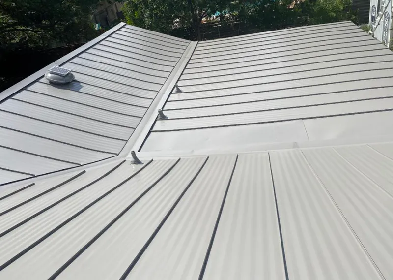 Solar attic fan installed on a metal roof for Roof Ventilation in Carroll